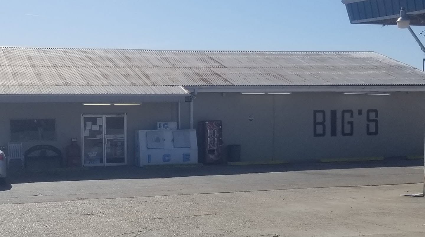 The Big's Place building with its corrugated metal roof, ice chest and vending machine by the door