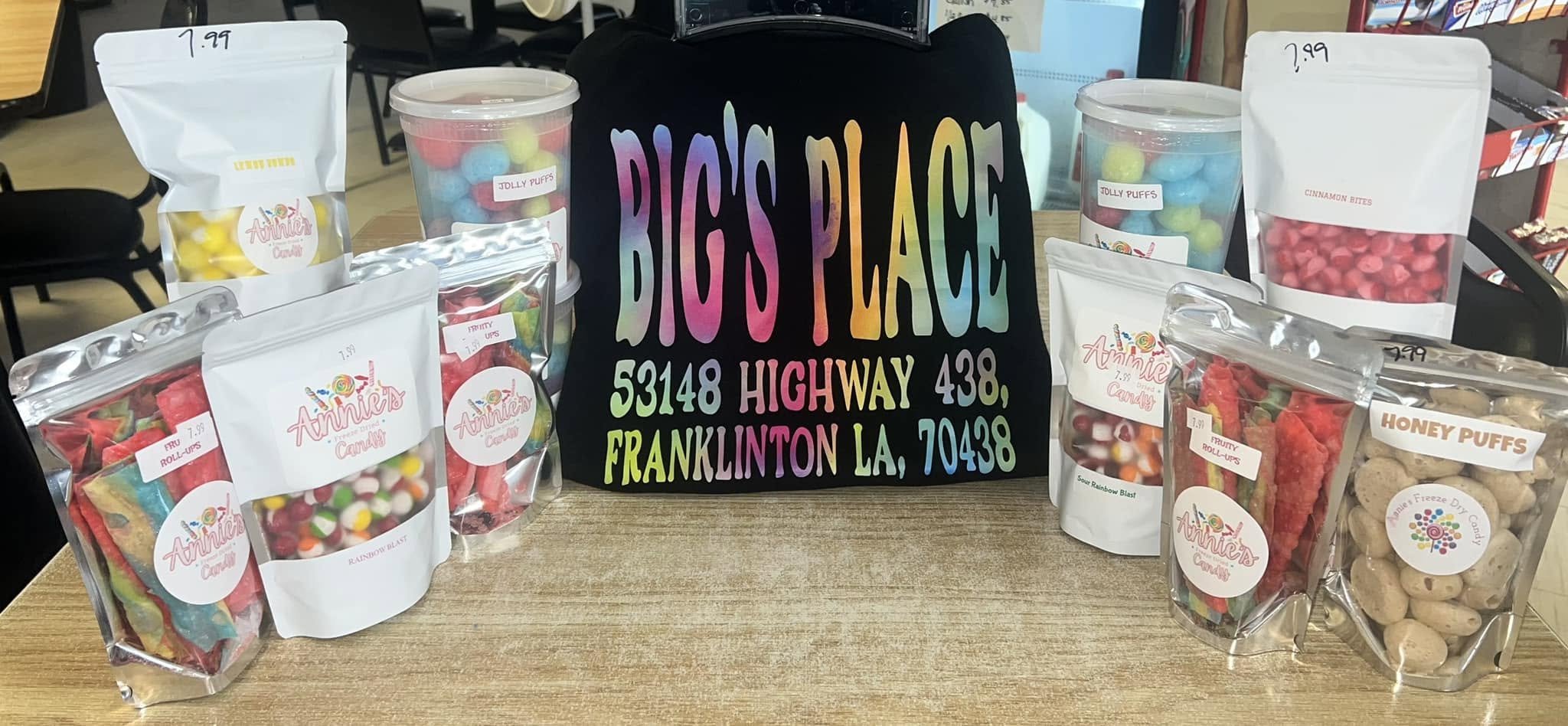 Bags of colorful freeze-dried candy on a shelf with a Big's Place tote bag