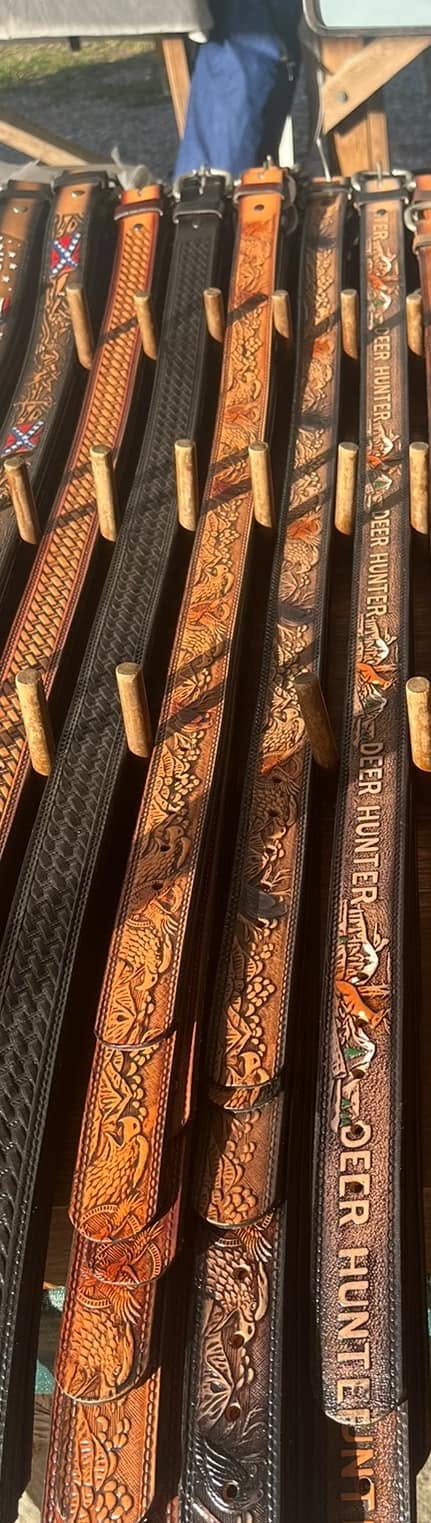 Deer Hunter embossed leather belts on wooden pegs